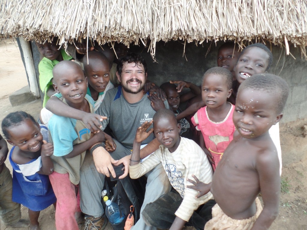 Cody Blumenshine surrounded by village kids in Uganda.