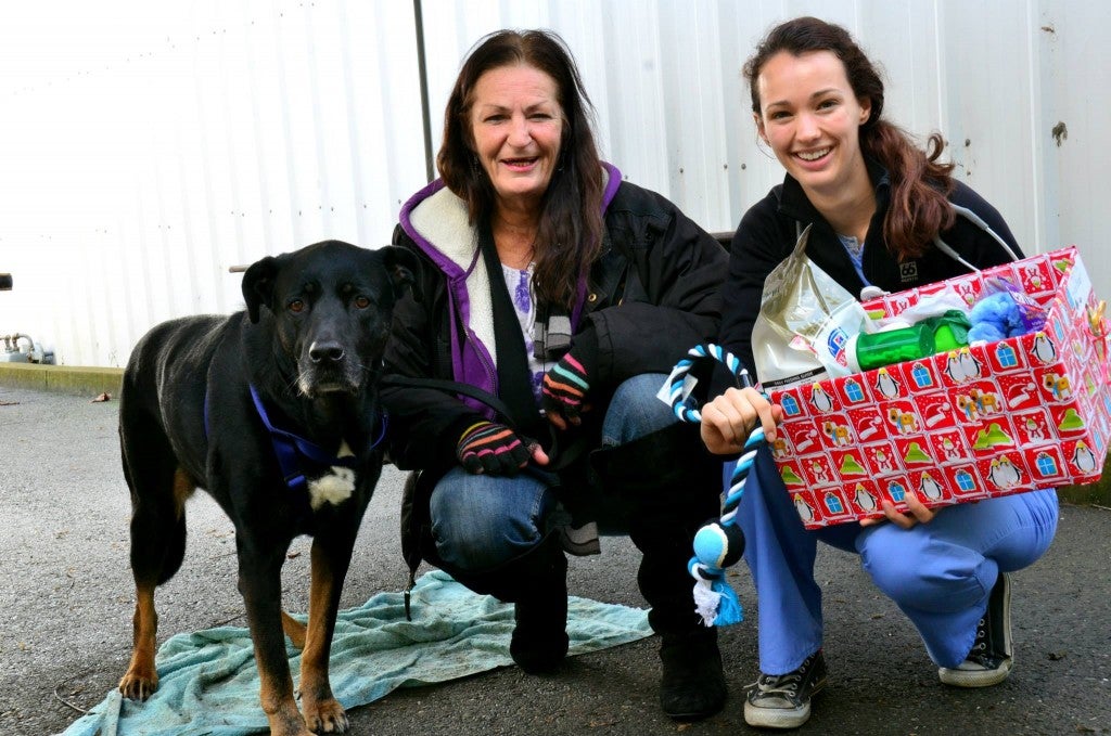 Veterinary student Corinna Esdorn (Class of 2017) handing out a holiday gift basked to a Mercer client.