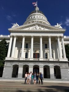 In front of the CA State Capitol Building in Sacramento, from left to right: Vicky Yang, Julie Dobbs, Elizabeth Tenborg, Jenny Tsai, Audrey Buatois, Elizabeth Malcolm, Roxana Bordbar, Christina Thompson. 